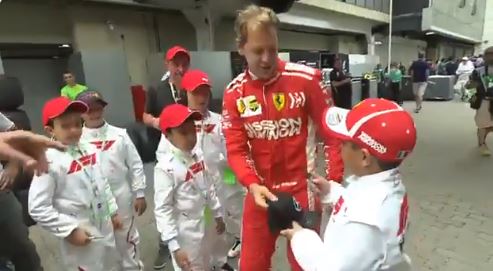 F1 - Simpatica scenetta in Brasile: Vettel ruba ad un grid boy il cappellino  Mercedes e lo lancia a terra, ma poi [VIDEO]