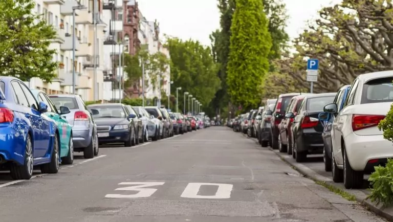 Rows of cars parked on the roadside in residential district