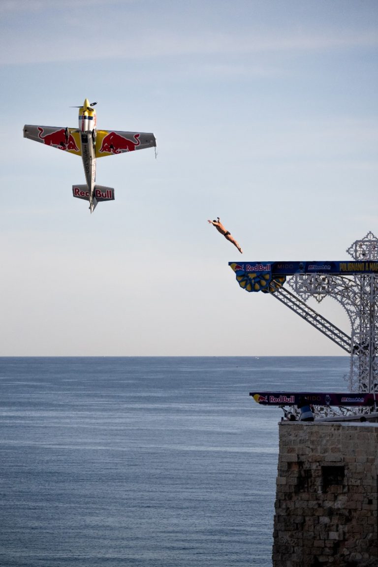 Independent Athlete, Artem Silchenko (R) dives from the 27 metre platform as Dario Costa (L) of Italy flies by during the Volare project prior to the seventh stop of the Red Bull Cliff Diving World Series in Polignano a Mare, Italy on September 14, 2022. // Romina Amato / Red Bull Content Pool // SI202209140498 // Usage for editorial use only //
